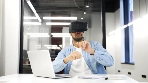 Young adult african american businessman works using VR glasses in virtual reality simulator sitting