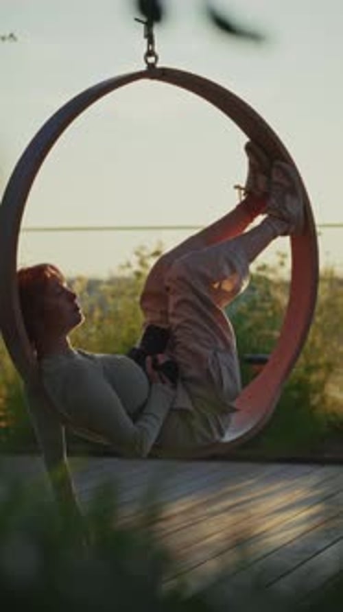 Young Photographer Relaxing On Outdoor Swing Chair