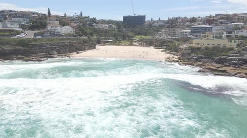 Beachgoers Enjoying Cool Ocean Waves In Summer. Tamarama Beach In Sydney, NSW, Australia. drone pull