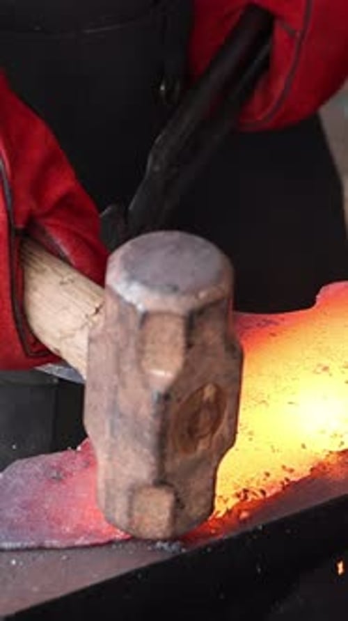 Blacksmith Shaping Hot Metal with Hammer and Tongs