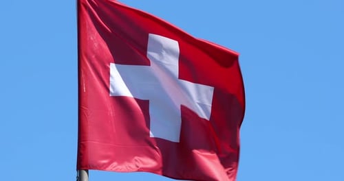 Swiss Flag Waving Against Blue Sky