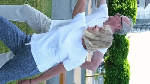 Elderly Married Couple is Exercising Doing Yoga Outdoors on the Green Lawn of the Park at Dawn