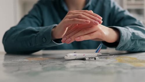 Young Adult Planning Travel with Airplane Model
