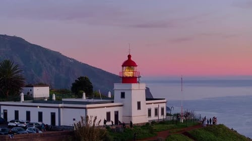 Sunset view of coastal lighthouse illuminating the ocean landscape