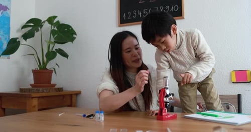 Woman and Boy Explore Science With a Microscope