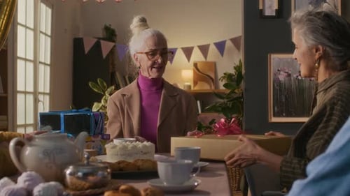 Seniors Celebrating Birthday with Gifts and Cake