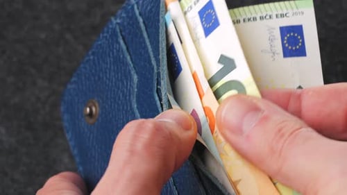 A Closeup View of Cash Being Stored in a Blue Wallet for Financial Purposes