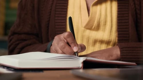 Close Up of Adult Writing in Journal