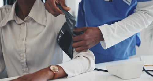 Doctor, patient and blood pressure at the hospital in healthcare appointment