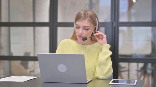 Blonde Woman with Headset in Call Center Talking During Video Chat