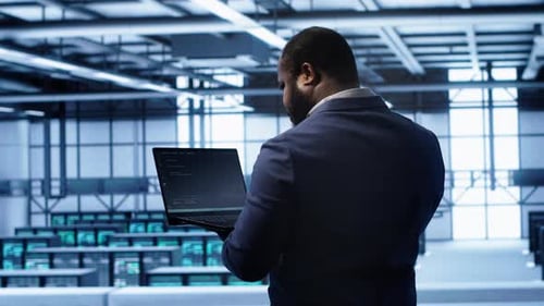 Computer Scientist in Server Farm Using Laptop to Patch Network Issues