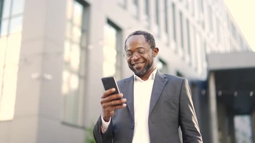 Man in Suit Using Phone in City