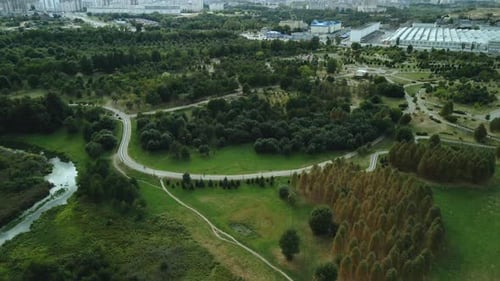 Winding bike path in the city park. City park at dawn. Aerial photography.