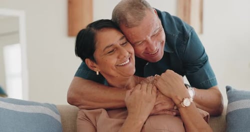 Mature Couple Laughing and Embracing on Couch