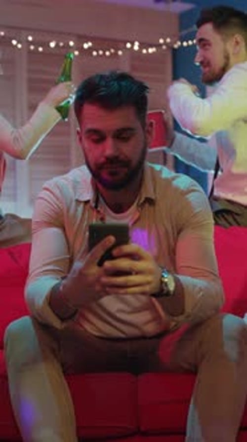 Man Uses Phone at a Birthday Party