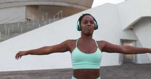 Fit Young African Woman Doing Sport Stretching Workout in City While Listening