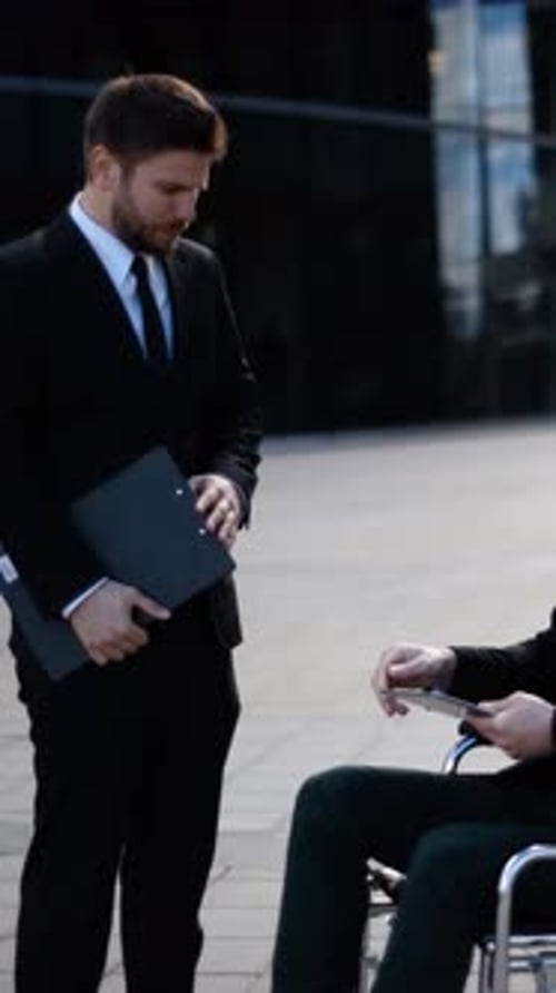 Vertical d'un jeune entrepreneur handicapé et homme d'affaires discute avec ses collègues et signe des documents Textpad
