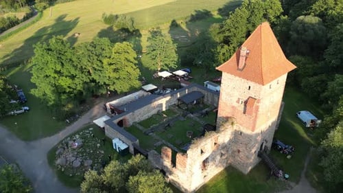 Medieval Chudow castle with a tower, walls, and courtyard during a beautiful summer day surrounded b