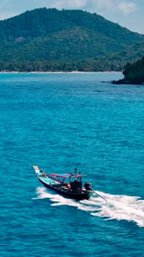 Longtail Boat Cruising in Tropical Blue Ocean