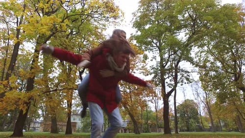 Happy young couple having fun together in autumn park romance and love