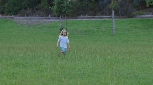 Young Boy Running in a Green Meadow