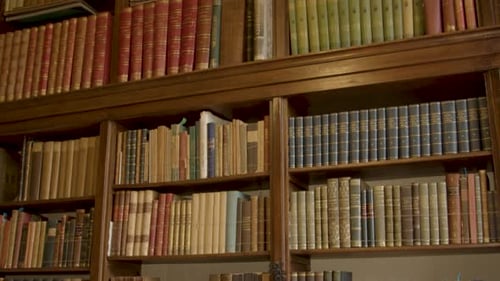 Tilt down over collection of old books in luxurious private library