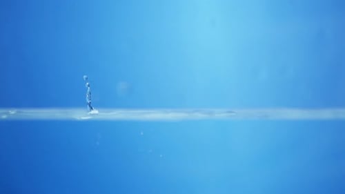 Droplets splashing on water surface close up shot