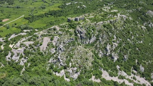 Aerial View of an Ancient Majestic Stone Fortress Located on Top of a Steep Rocky Mountain