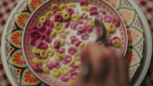 Bowl of Cereal Being Mixed with a Spoon