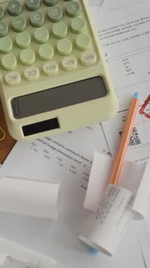 Vertical of Past-Due Bills and Calculator Arranged on Table
