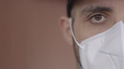 Young adult smiles and removes face mask