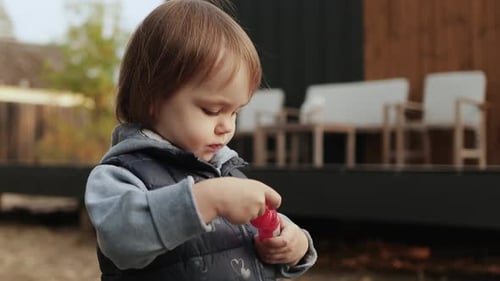 Adorable Child Playing Bubbles Outside on Cloudy Day