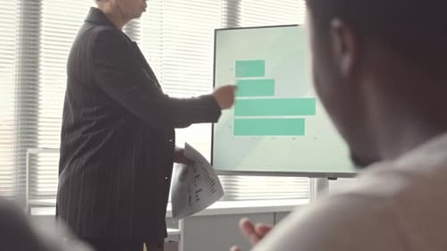 Businesswoman Discussing Financial Statistics of Company during Meeting