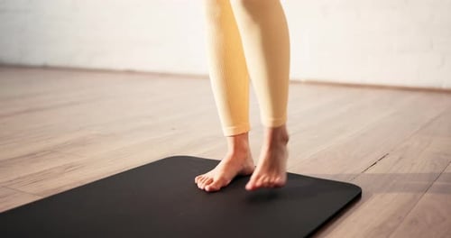 Person, feet and yoga with mat in studio for spiritual wellness, start or preparation