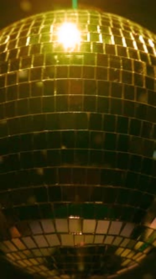 Dazzling disco ball illuminates dance floor during vibrant party. Vertical