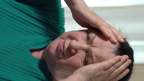 Senior Woman With Headache Examines Pills