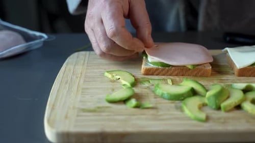Preparing Avocado Toast With Ham and Cheese