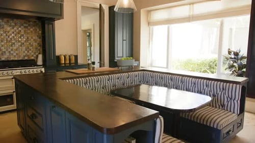 Modern kitchen with built-in dining nook and large windows, creating cozy atmosphere, copy space