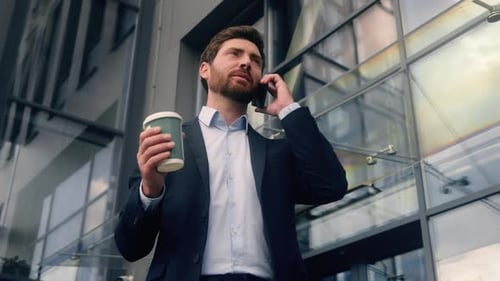 Middleaged Caucasian Business Man Talking Mobile Phone in City Holding Cup of Coffee Businessman