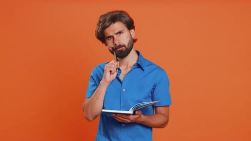 Young Adult Man Writing in a Notebook