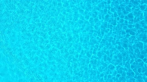 Blue Water in the Swimming Pool with Light Reflections
