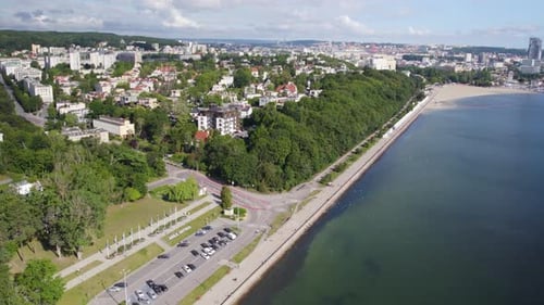Vue aérienne du boulevard en bord de mer avec des bâtiments entourés d'arbres au feuillage luxuriant à Gdynia, Pol