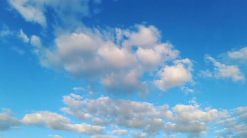 Fluffy White Clouds Drifting Across a Blue Sky