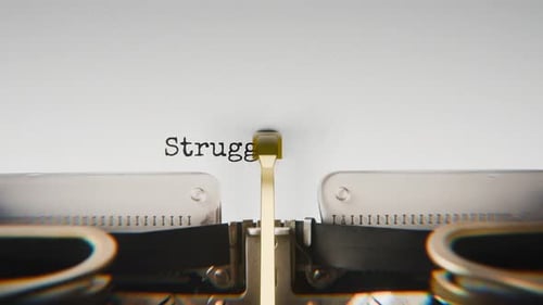 Old mechanical typewriter typing Struggle And Triumph in a close-up view.
