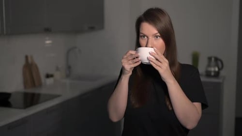 Woman Drinks From a Mug in Modern Kitchen
