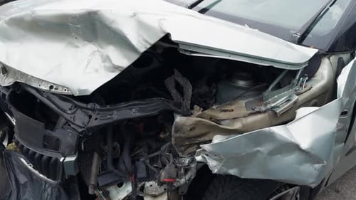 Damaged Vehicle Parked Roadside with Flat Tire and Dented Bumper Postaccident