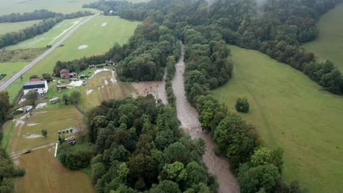 Drone shot of overflowing river with road and mist