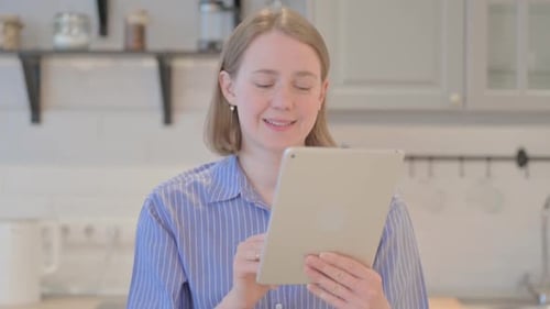 Woman Waving During Video Chat on Tablet Indoors