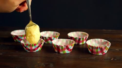 Pouring cake dough into muffin tray for delicious homemade cupcakes