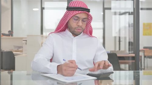 Adult using Calculator in Office